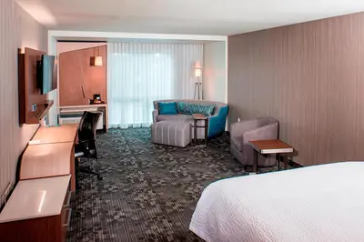 a hotel room with a bed and a living room at Courtyard by Marriott Albany Clifton Park in Clifton Park