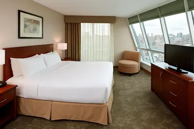 a hotel room with a large bed and a television at LIC Manhattan View Hotel in Queens