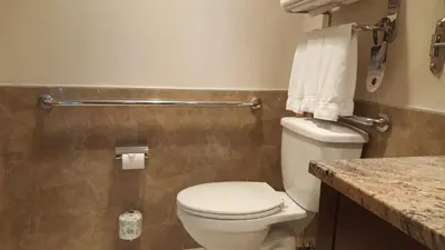 a bathroom with a white toilet and a counter at LIC Manhattan View Hotel in Queens
