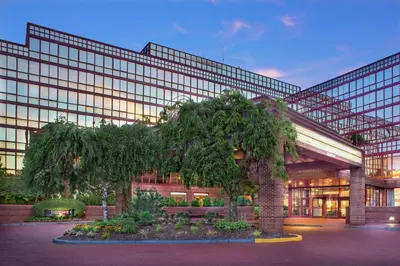 a large building with trees in front of it at DoubleTree by Hilton New York-LaGuardia in Queens