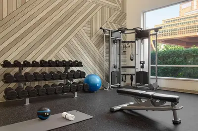 a fitness room with a gym with weights and a simulator at DoubleTree by Hilton New York-LaGuardia in Queens