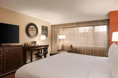 a hotel room with a bed and a desk and a television at DoubleTree by Hilton New York-LaGuardia in Queens