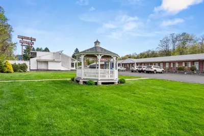 a gazebo on a lawn in front of a hotel at Ardsley Acres Hotel Court in Ardsley