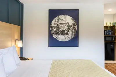 a bedroom with a bed and a picture on the wall at Ardsley Acres Hotel Court in Ardsley