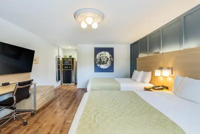 a hotel room with two beds and a desk at Ardsley Acres Hotel Court in Ardsley