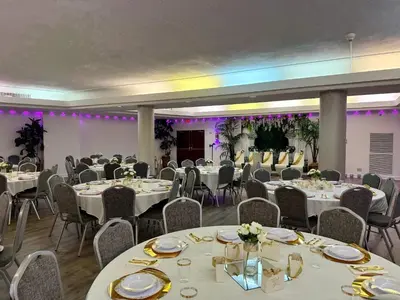 a banquet hall with white tables and chairs and purple lighting at Country Inn & Suites by Radisson, Downtown Albany New York in Albany