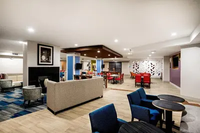 a lobby with chairs and tables and a fireplace at Country Inn & Suites by Radisson, Downtown Albany New York in Albany