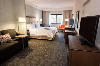 a hotel room with a bed and a flat screen tv at Hampton Inn Albany-Western Ave/University Area, NY in Albany