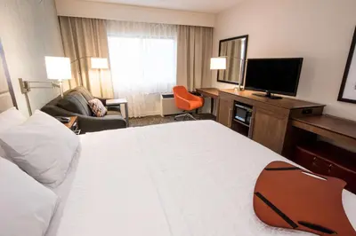 a hotel room with a bed and a flat screen tv at Hampton Inn Albany-Western Ave/University Area, NY in Albany