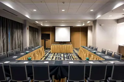 a conference room with a table and chairs and a screen at Hampton Inn Albany-Western Ave/University Area, NY in Albany