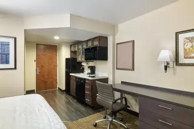 a hotel room with a bed and a desk and a kitchen at Candlewood Suites NYC -Times Square by IHG in New York