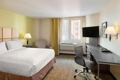a hotel room with a bed and a desk and a computer at Candlewood Suites NYC -Times Square by IHG in New York