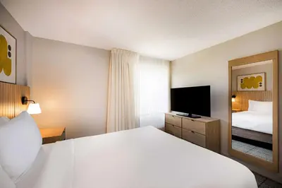 a hotel room with a bed and a television at Sonesta Simply Suites Jersey City in Jersey City