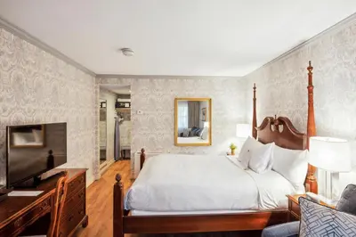 a bedroom with a large bed and a television at Avon Old Farms Hotel in Avon