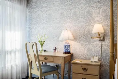 a desk with a lamp and a chair next to a desk with a lamp at The Farmington Inn and Suites in Farmington