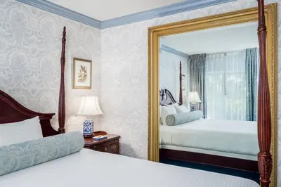 a bedroom with two beds and a mirror at The Farmington Inn and Suites in Farmington