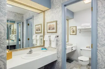 a bathroom with a sink and a toilet and a mirror at The Farmington Inn and Suites in Farmington