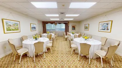 a banquet room with white tables and chairs at The Farmington Inn and Suites in Farmington