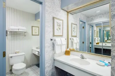 a bathroom with a sink and a toilet and a mirror at The Farmington Inn and Suites in Farmington