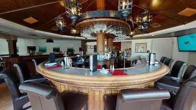 a bar in a restaurant with chairs around it at The Simsbury Inn in Simsbury