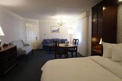 a hotel room with a bed and a table and a couch at The Simsbury Inn in Simsbury