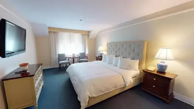 a hotel room with a bed and a television at The Simsbury Inn in Simsbury