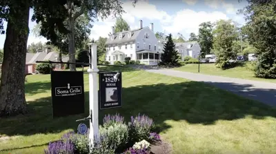 a house with a sign in front of a yard at Simsbury 1820 House in Simsbury