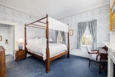 a bedroom with a canopy bed and a desk at Simsbury 1820 House in Simsbury