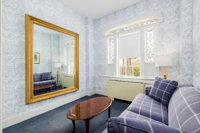 a living room with a purple couch and a mirror at Simsbury 1820 House in Simsbury