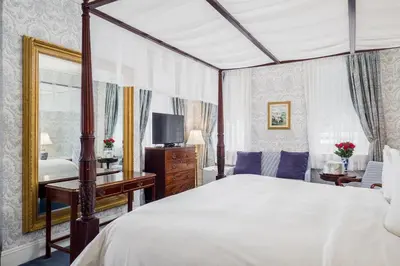 a bedroom with a large bed and a mirror at Simsbury 1820 House in Simsbury