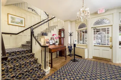 a staircase in a home with a piano and a desk at Simsbury 1820 House in Simsbury