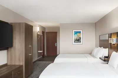 a hotel room with two beds and a flat screen tv at Holiday Inn Express & Suites East Greenbush Albany-Skyline by IHG in Rensselaer
