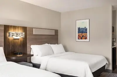 a hotel room with two beds and a table at Holiday Inn Express & Suites East Greenbush Albany-Skyline by IHG in Rensselaer