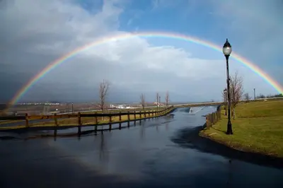 a rainbow in the sky over a river with a bridge at Holiday Inn Express & Suites East Greenbush Albany-Skyline by IHG in Rensselaer
