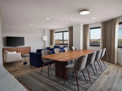 a dining room with a table and chairs and a couch at Sonesta White Plains Downtown in White Plains