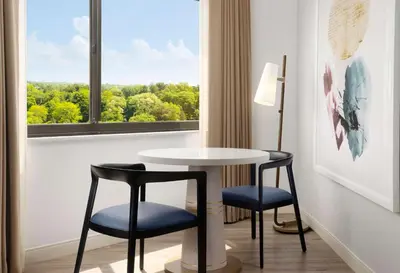 a table and two chairs in a room with a window at Sonesta White Plains Downtown in White Plains