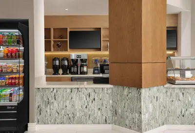 a kitchen with a drink bar with a refrigerator at Sonesta White Plains Downtown in White Plains
