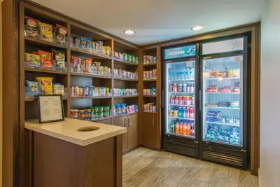 a store aisle with a refrigerator and shelves of food at Hotel MTK Mount Kisco in Mount Kisco