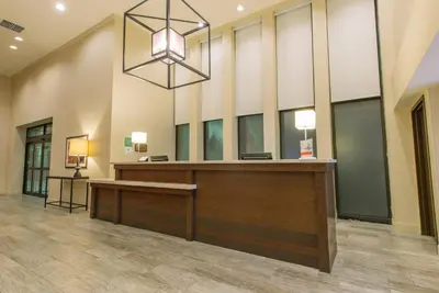 a lobby with a reception desk and a chandelier at Hotel MTK Mount Kisco in Mount Kisco