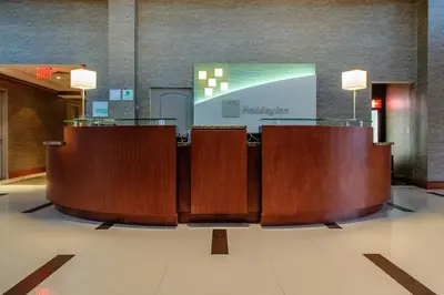 a row of brown chairs in a lobby at Holiday Inn Plainview-Long Island by IHG in Plainview