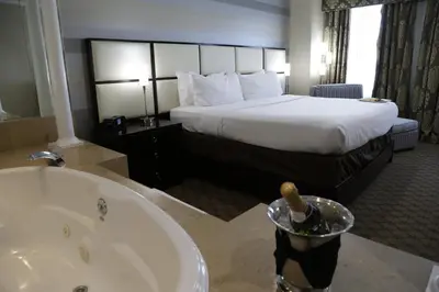a hotel room with a bed and a bath tub at Holiday Inn Plainview-Long Island by IHG in Plainview