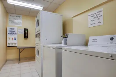 a kitchen with a white refrigerator and a counter at Holiday Inn Westbury-Long Island by IHG in Carle Place