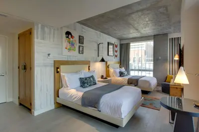 a hotel room with two beds and a table at Hotel 50 Bowery, part of JdV by Hyatt in New York
