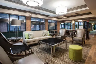a lobby with a couch and chairs and a table at Holiday Inn Saratoga Springs by IHG in Saratoga Springs