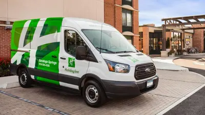 a green and white van parked in front of a building at Holiday Inn Saratoga Springs by IHG in Saratoga Springs