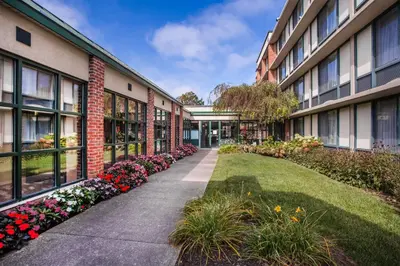 a courtyard of an apartment building with flowers at Holiday Inn Saratoga Springs by IHG in Saratoga Springs