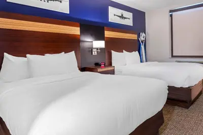 a hotel room with two beds and a window at Avion Inn Near LGA Airport, an Ascend Collection Hotel in Queens