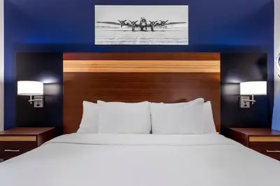 a bed in a hotel room with two men in a rowing race at Avion Inn Near LGA Airport, an Ascend Collection Hotel in Queens