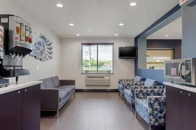a waiting room with couches and a tv in a hospital at Avion Inn Near LGA Airport, an Ascend Collection Hotel in Queens