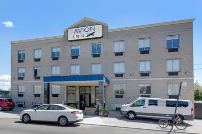 a building with a van parked in front of it at Avion Inn Near LGA Airport, an Ascend Collection Hotel in Queens